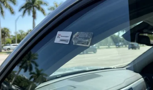 A rental car windshield showing the built-in toll transponder box closed in shield mode to avoid double billing