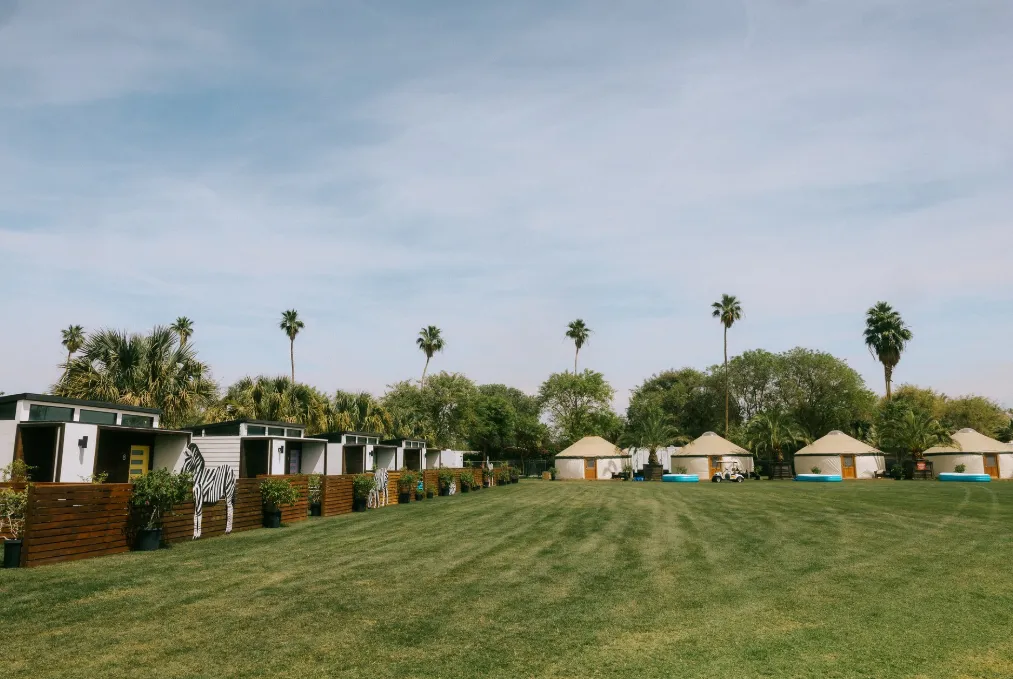 A well-prepared Coachella car camping site featuring a straight-leg canopy, tapestries, and a parked vehicle
