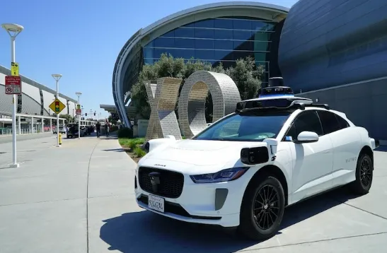 A driverless Waymo autonomous vehicle picking up passengers at the SJC San Jose Mineta Airport terminal